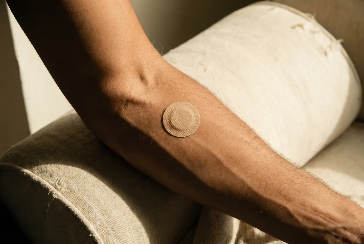 Close-up of a Korven dopamine patch adhered to a man's inner forearm.