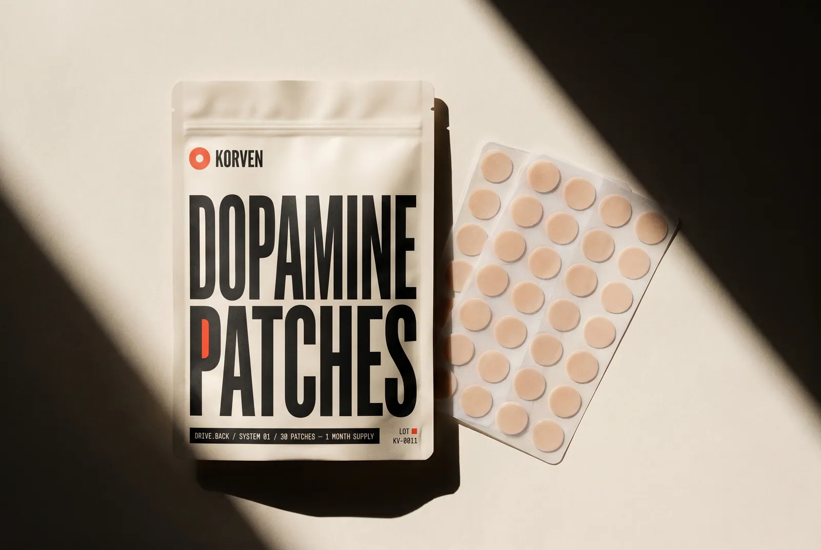 Korven Dopamine Patches pouch beside a sheet of skin-tone transdermal patches on a bone-cream backdrop.